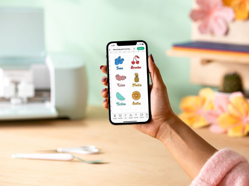 Woman's hand holding a smart phone with a personalized project template pulled up using Cricut's Design Space app